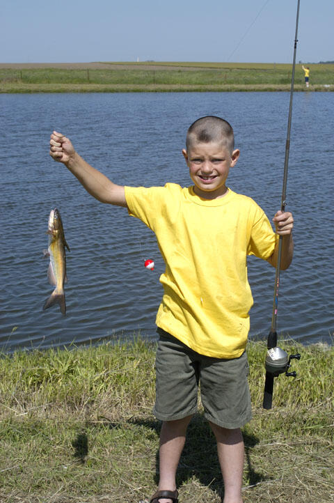 A young angler holds his latest catch