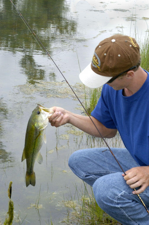 A young angler pulls a bass from the water