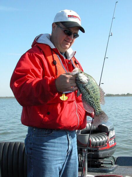 An angler holds a crappie